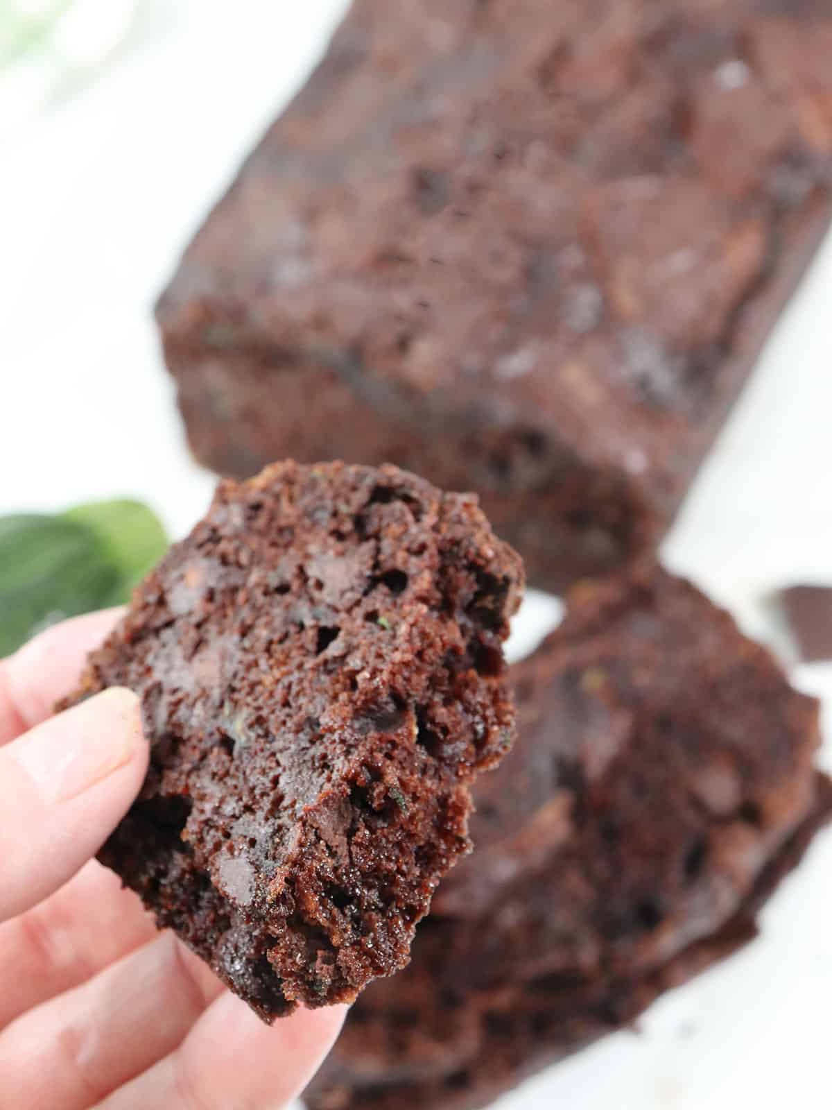 Holding a piece of double chocolate zucchini bread.