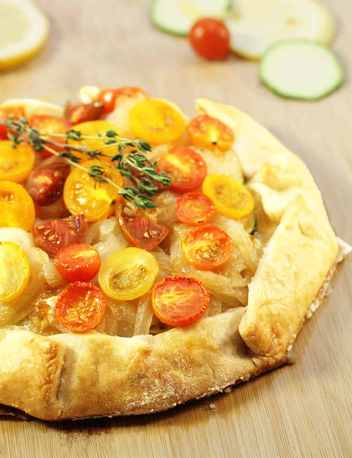 Closeup of inside showing tomatoes onions and the golden crust on wooden board.