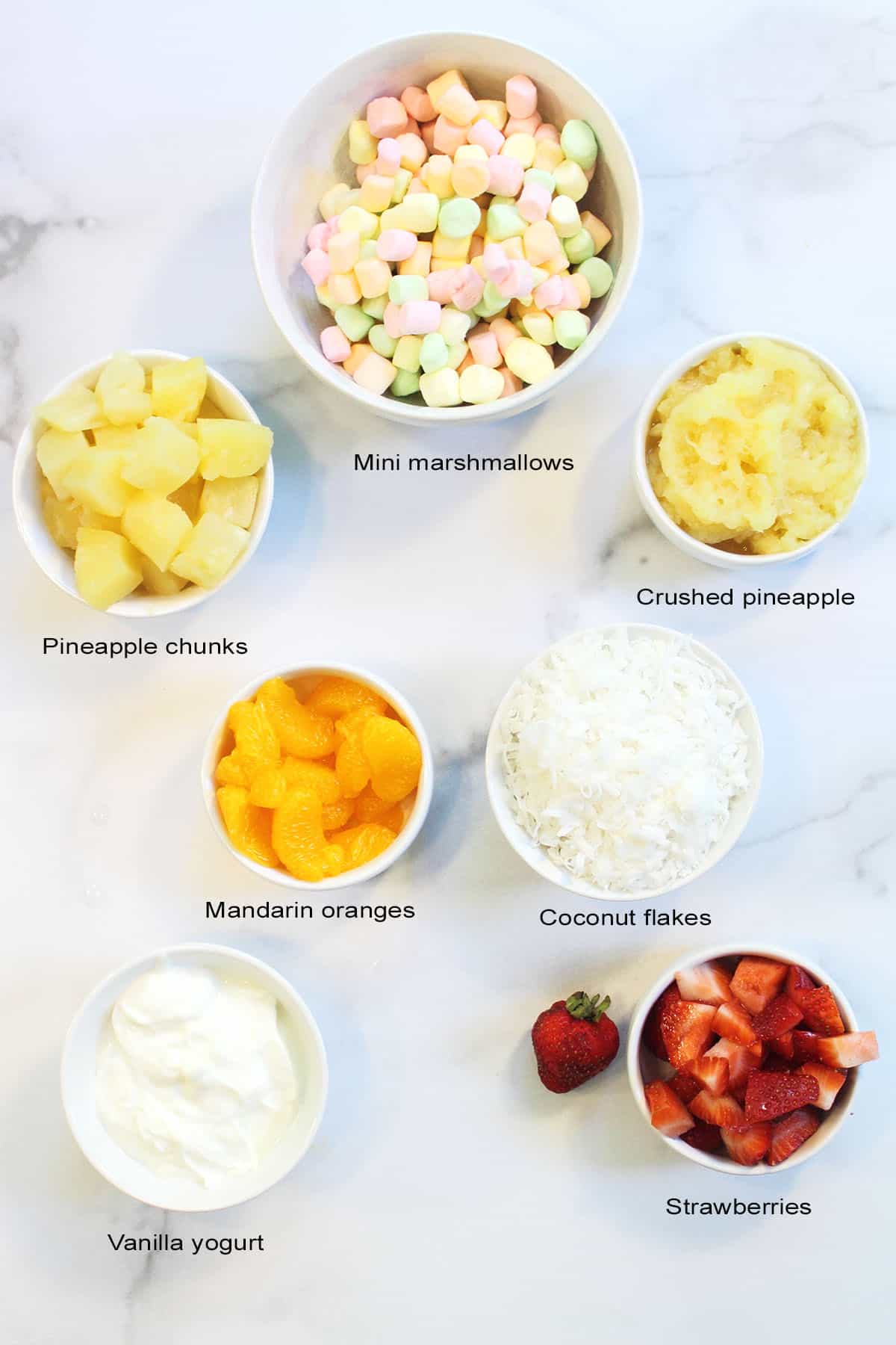 Ingredients for salad in bowls on white table.