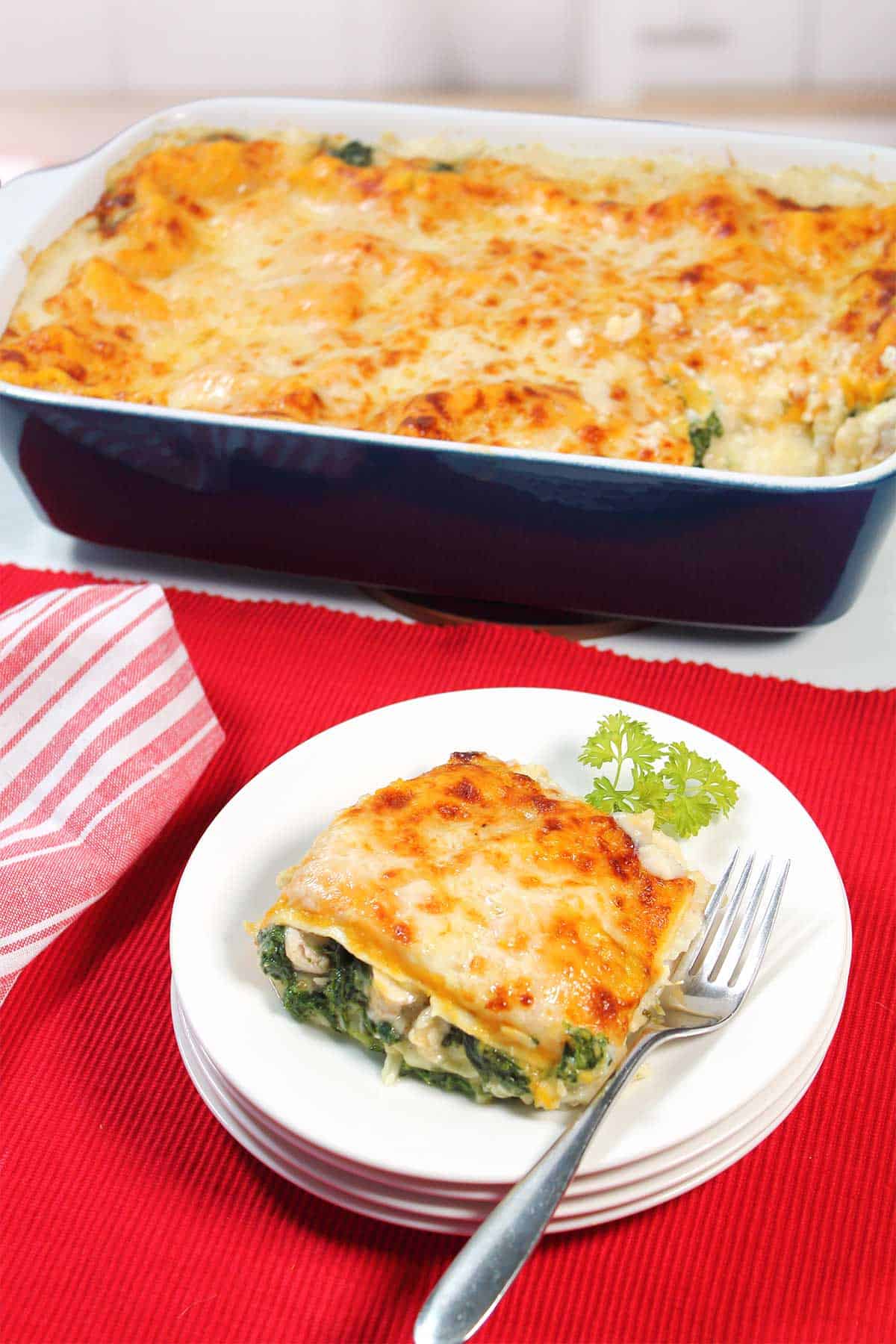 Plated Creamy White Chicken Lasagna serving with casserole.