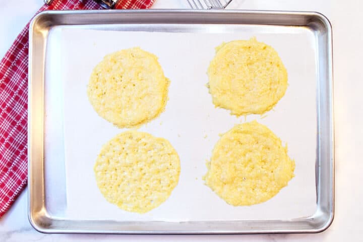 Baked cheese tacos on cookie sheet.