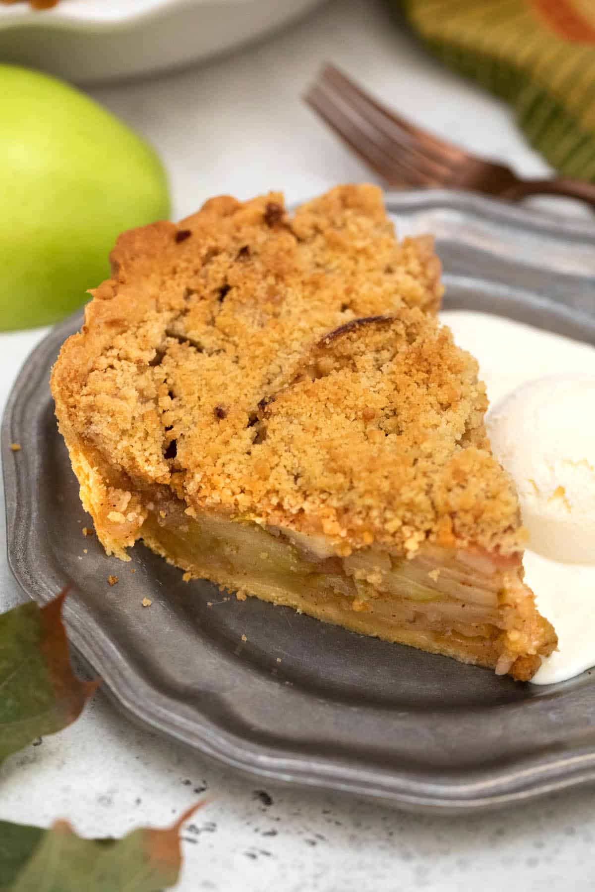 Closeup of slice of French Apple Pie with scoop of ice cream.