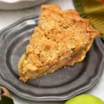 Slice of apple pie on pewter plate.