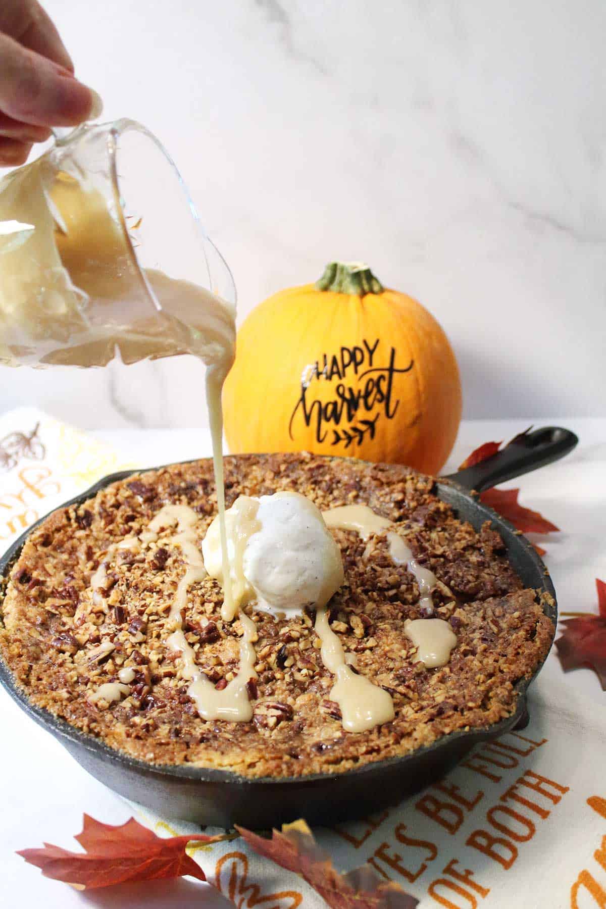 Pouring maple sauce over pumpkin cake with cake mix.