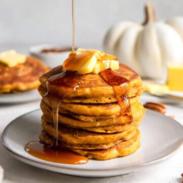 Pouring syrup over easy Pumpkin Pancakes.