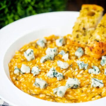 Pumpkin Risotto with bleu cheese in bowl with crumbled cheese on top.