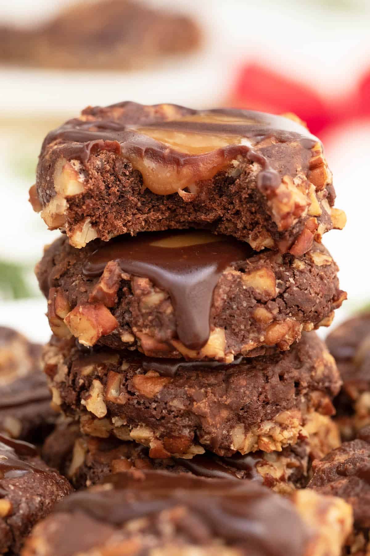 Stack of turtle thumbprint cookies with bite taken out of top one.