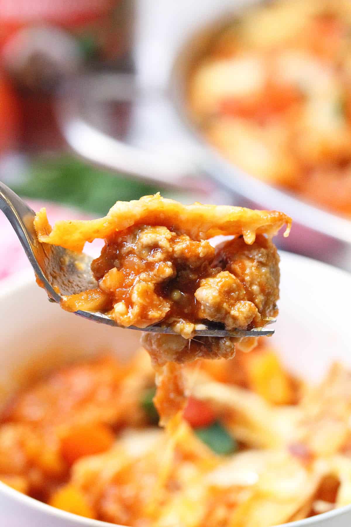 Closeup of bite on fork over bowl.