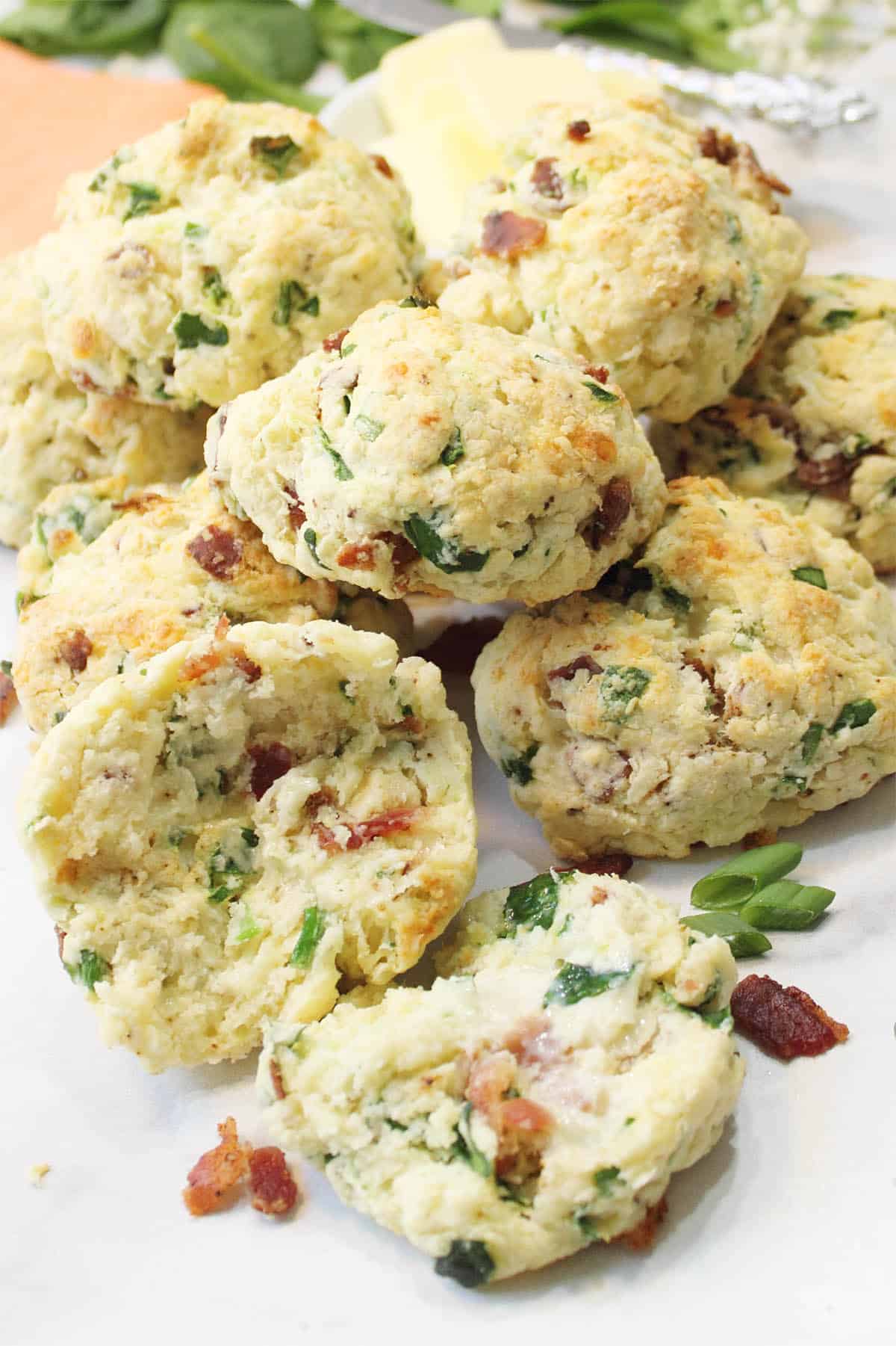 Closeup of stack of ham and cheese scones with the front one halved with butter on it.
