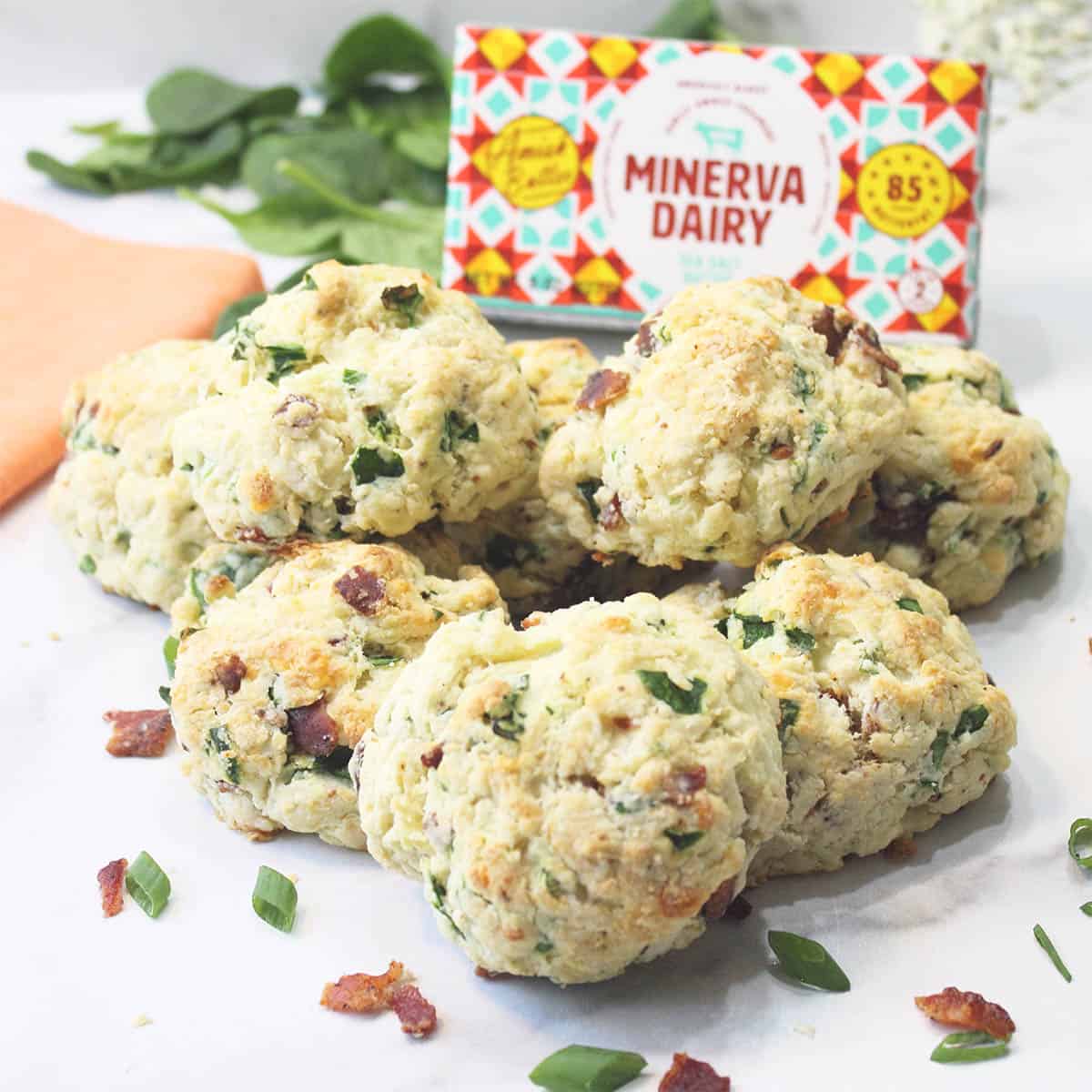 Group of ham and cheese scones in front of Minerva butter.