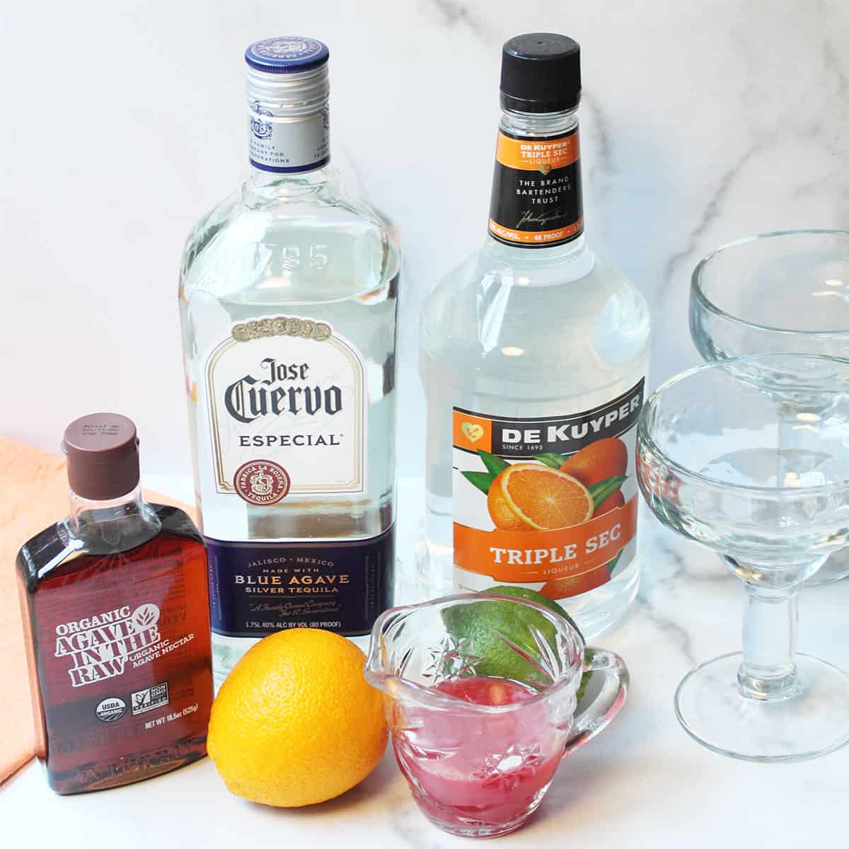 Ingredients for blood orange margarita on white table.