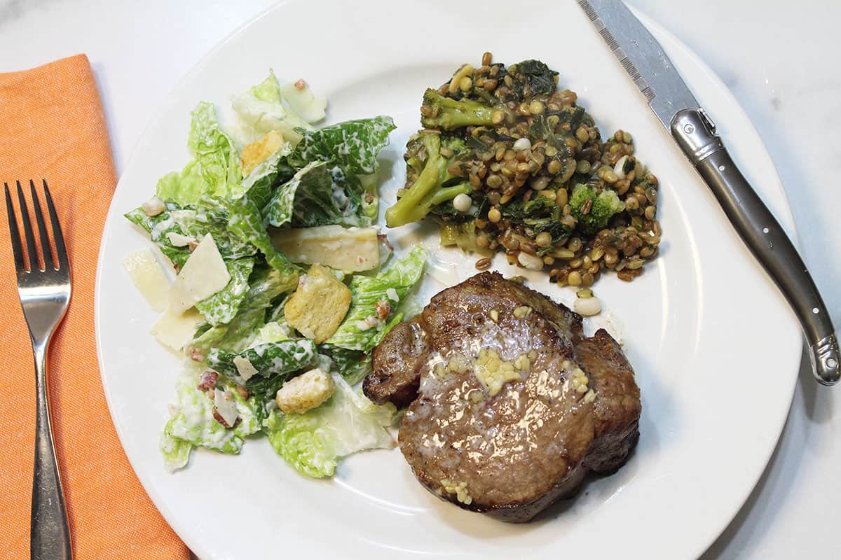 Overhead air fryer steak dinner on white plate.