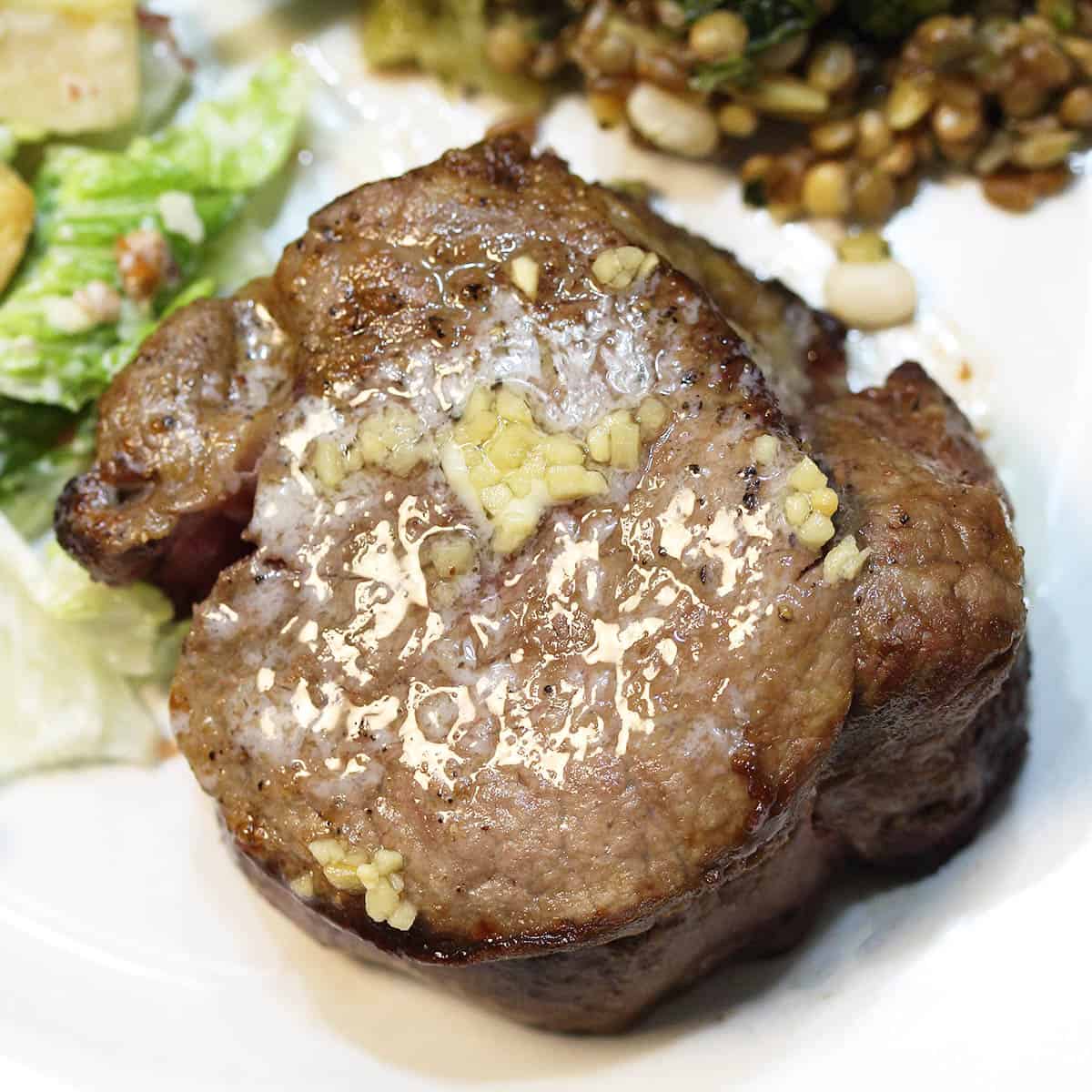Overhead of steak on dinner plate.