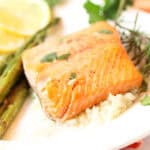 Plated air fryer salmon fillets with lemons.