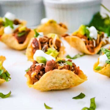 Mini Taco Bowls with sour cream garnish.