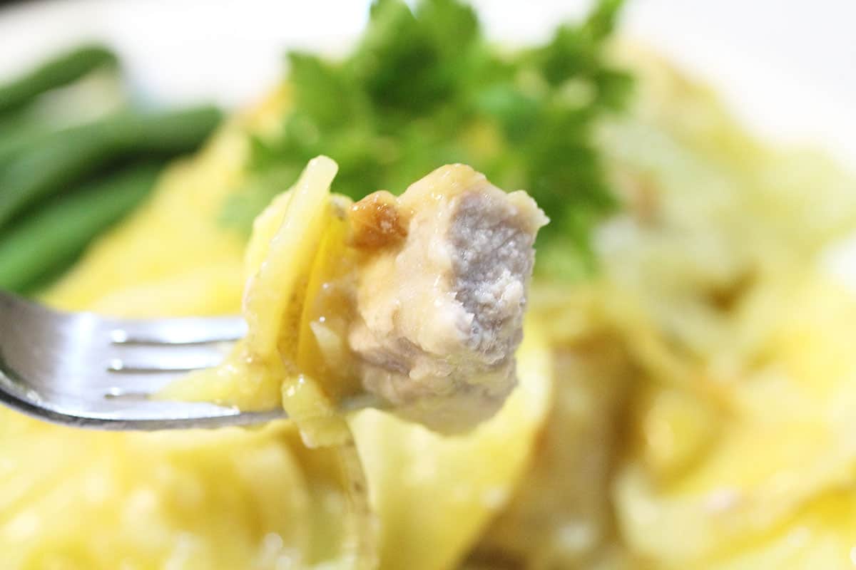 Bite of pork chop casserole on fork.