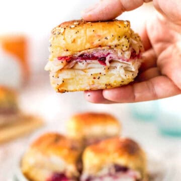 Holding a turkey slider over platter.