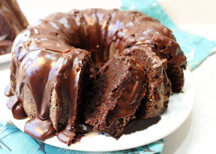 Homemade pound cake with chocolate ganache sliced on platter.