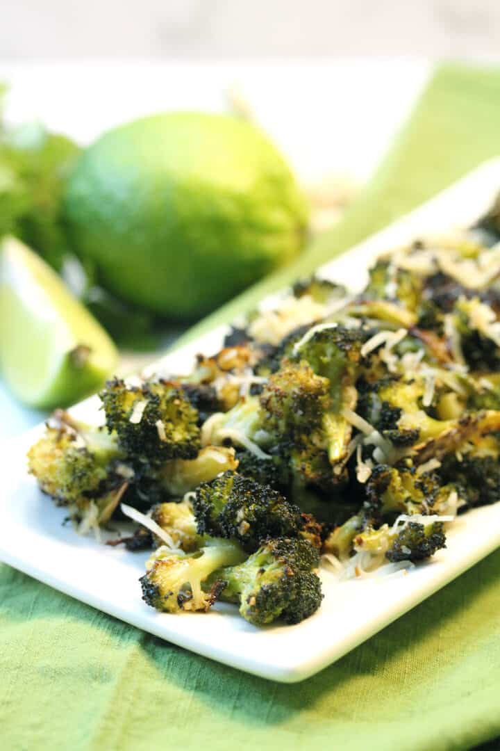 Closeup of platter of roasted broccoli on green napkin.