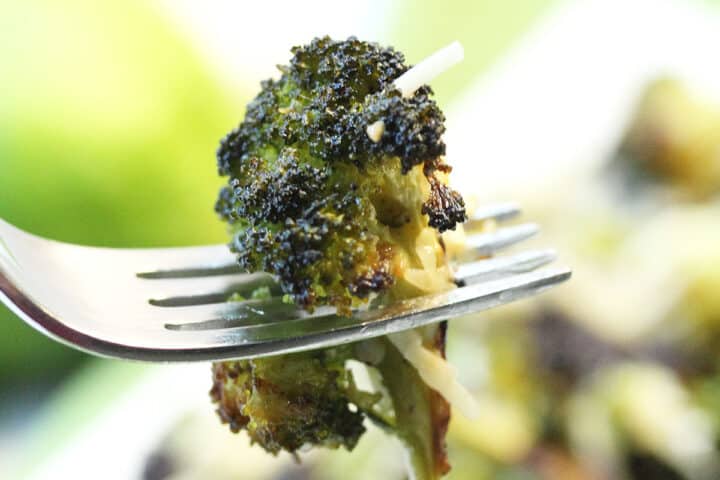 Closeup of forkful of roasted broccoli.