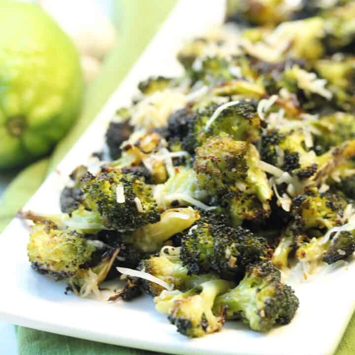 Platter of roasted broccoli with parmesan sprinkled over it.
