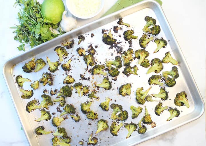Overhead of roasted broccoli on baking sheet.
