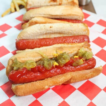 Air Fryer hot dogs lined up on red checkered paper.