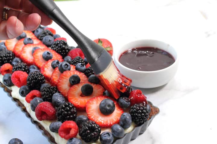 Brushing jam glaze on fruit.