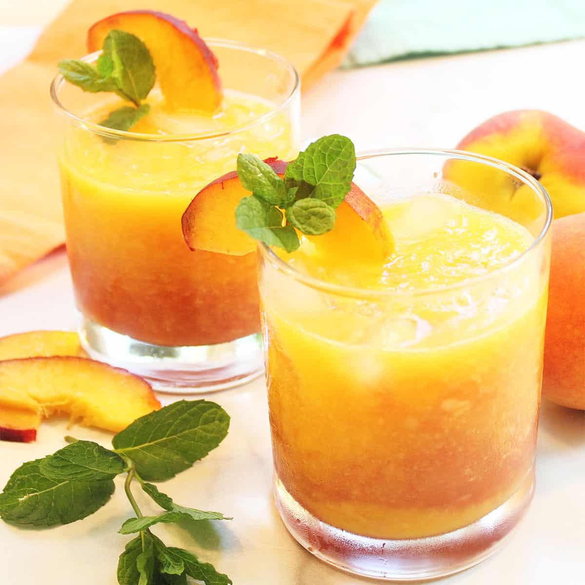 Two garnished fresh Georgia Peach Cocktails with vodka.