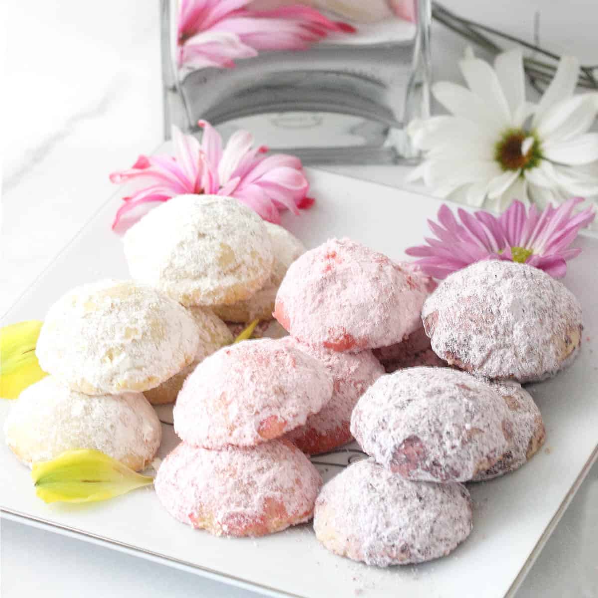 Pastel cookies in pink, purple and yellow, on serving plate.