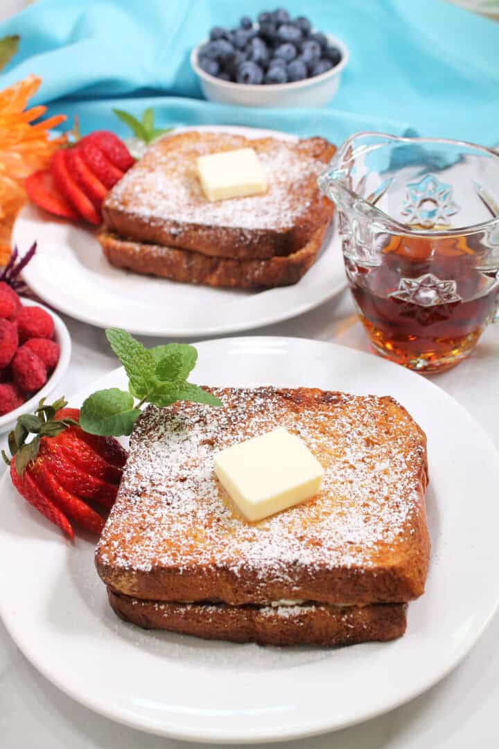 Two servings Air Fryer Cannoli Stuffed French Toast topped with butter.