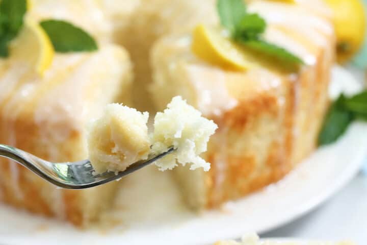 Bite of cake on fork in front of whole cake.