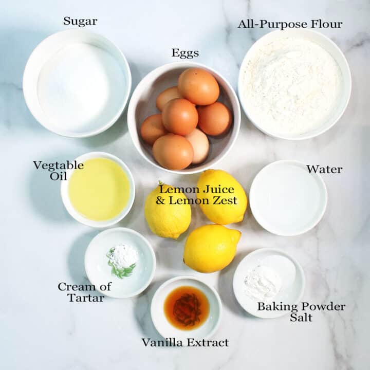 Overhead of lemon chiffon cake ingredients on marble table.