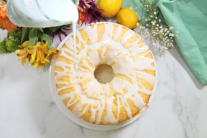Drizzling lemon glaze over cooled cake.
