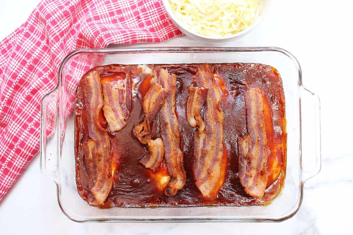 Cooked bacon on top of each chicken breast.