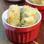 A bowl of fried zucchini on wooden board.