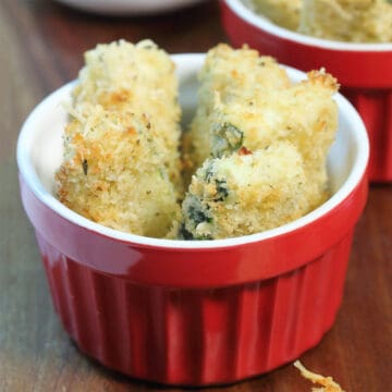 A bowl of fried zucchini on wooden board.