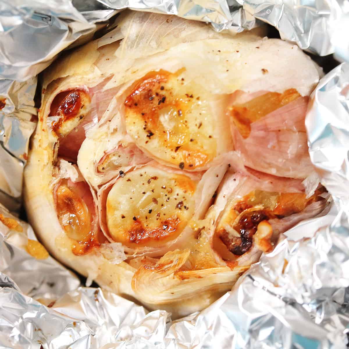Closeup of roasted garlic in foil.