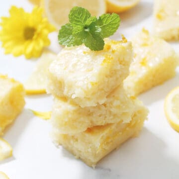 Stack of lemon brownies with mint leaf on top.
