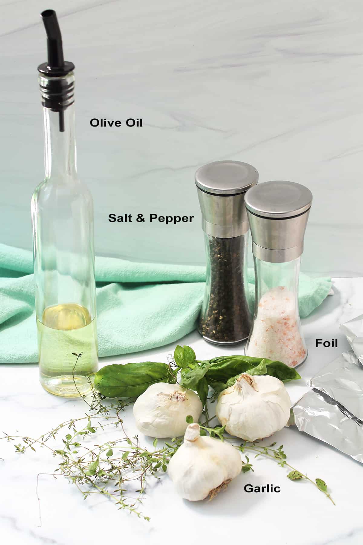 Roasted garlic ingredients, labeled, on white table.