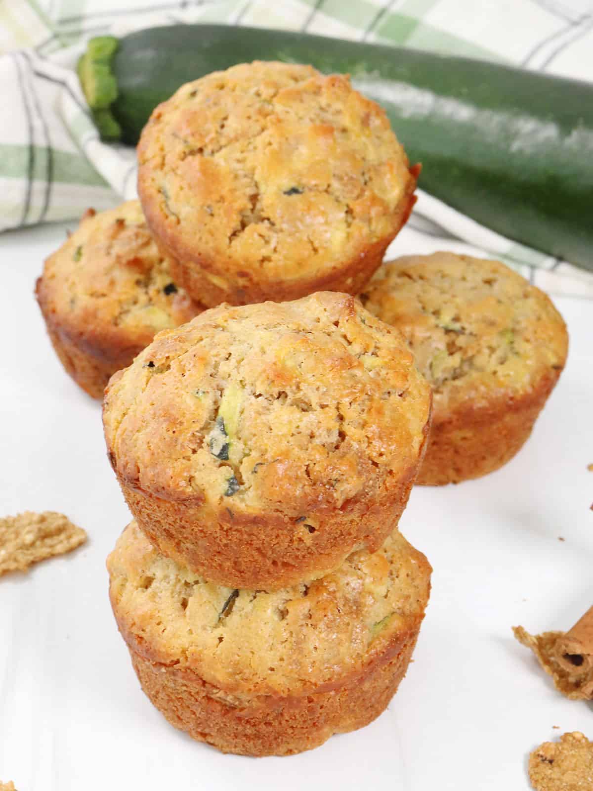 Stacked Zucchini Bran Muffins with zucchini in back.