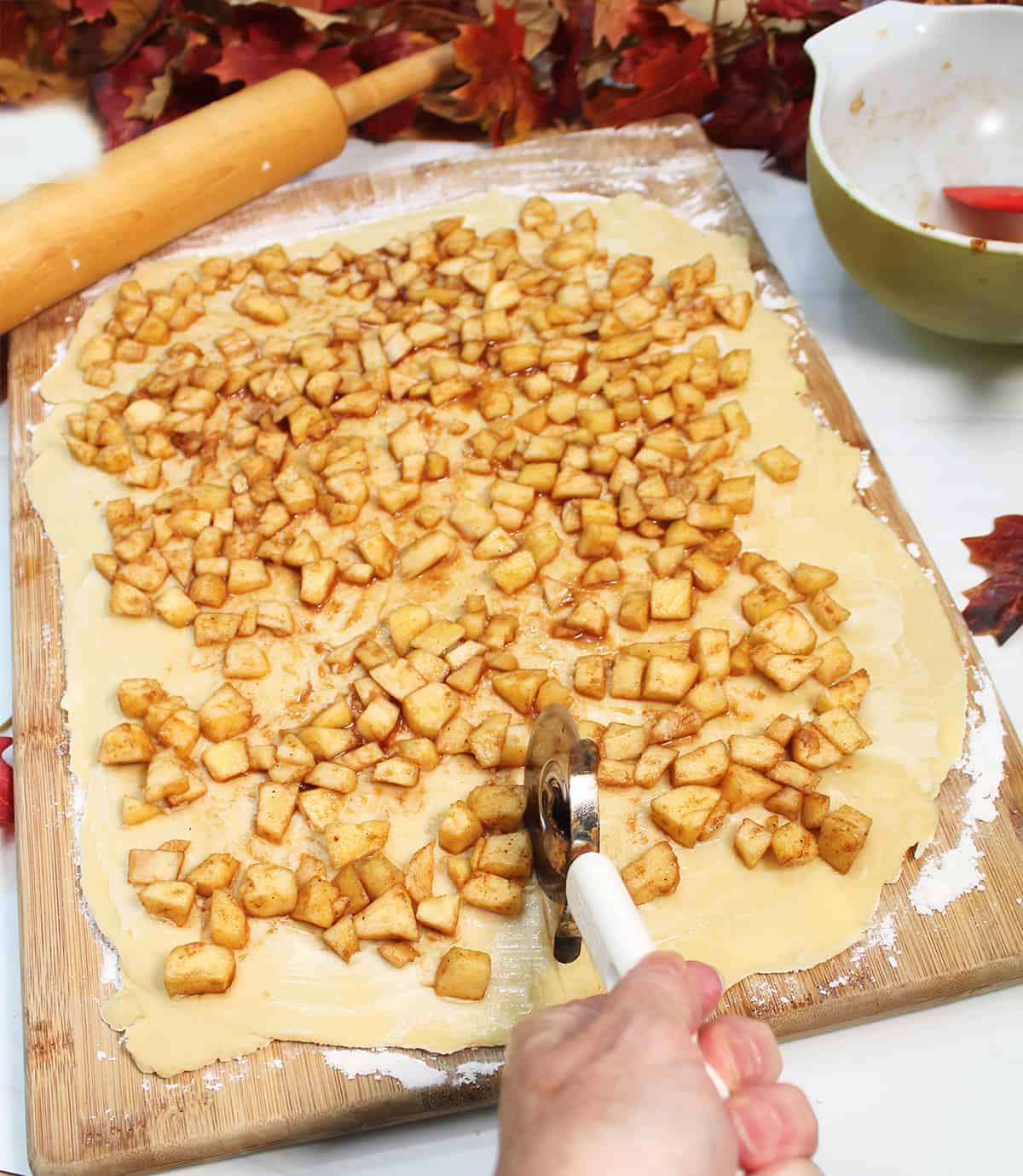 Cut down center of apple topped bread dough.
