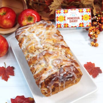 Glazed pull-apart bread on white platter with butter package.
