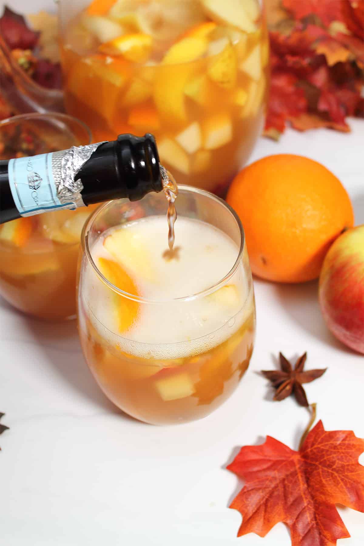 Adding prosecco to sangria in glass.