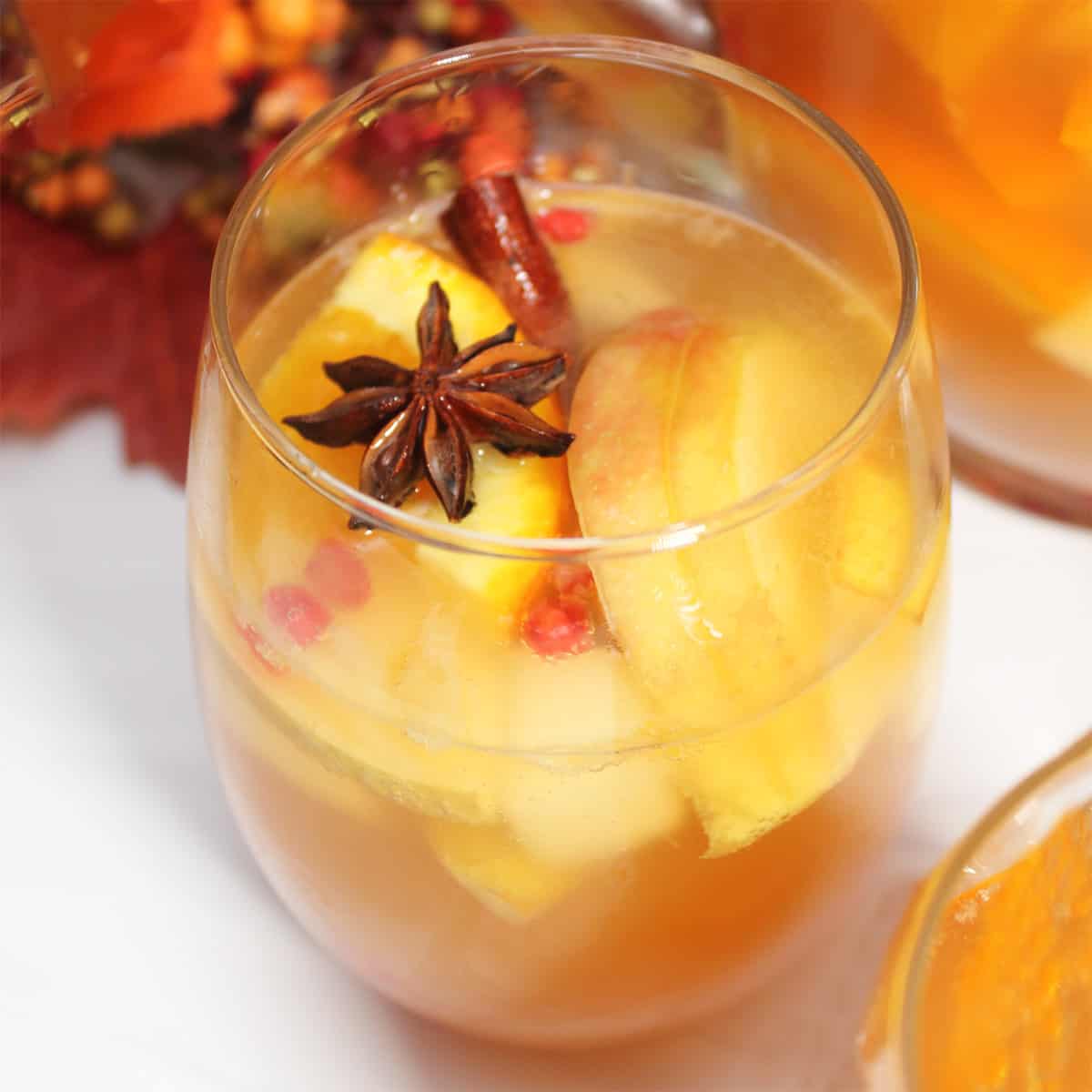 Closeup of glass filled with sangria with star anise and cinnamon stick garnish.