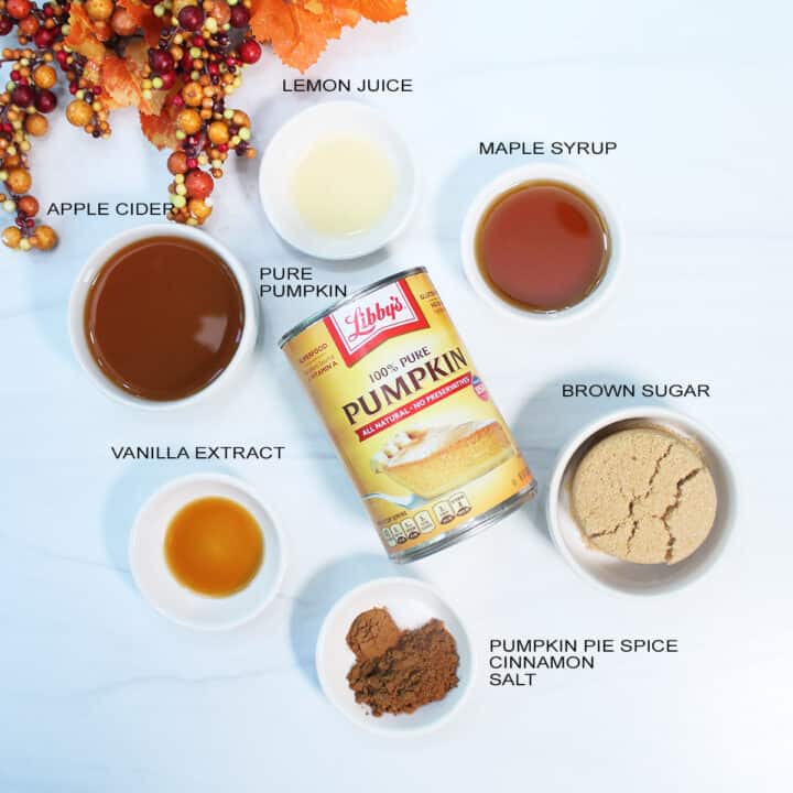 Overhead of ingredients for butter on white table.