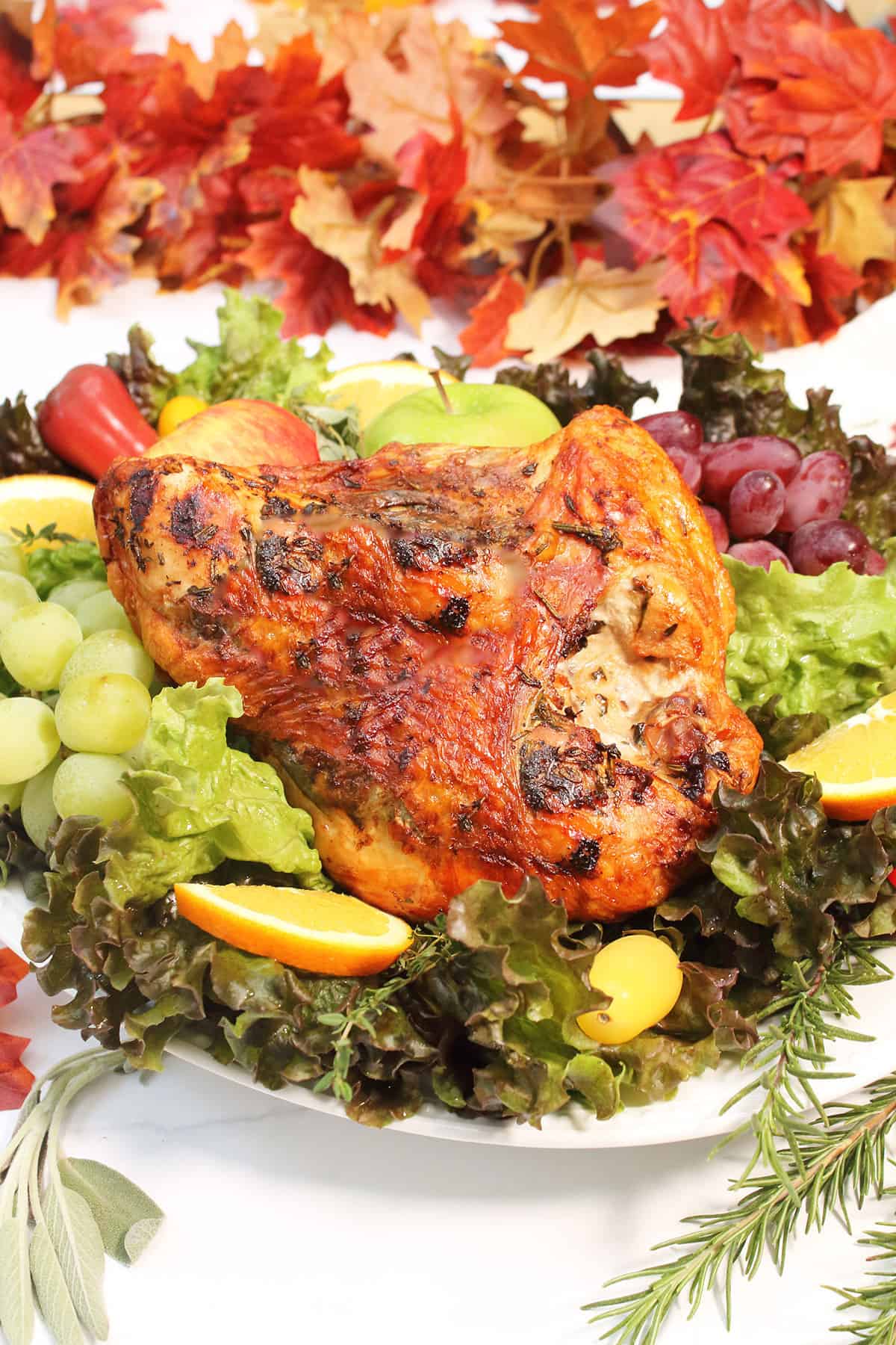 Air Fried turkey breast with herb butter on platter with fruits and greens.