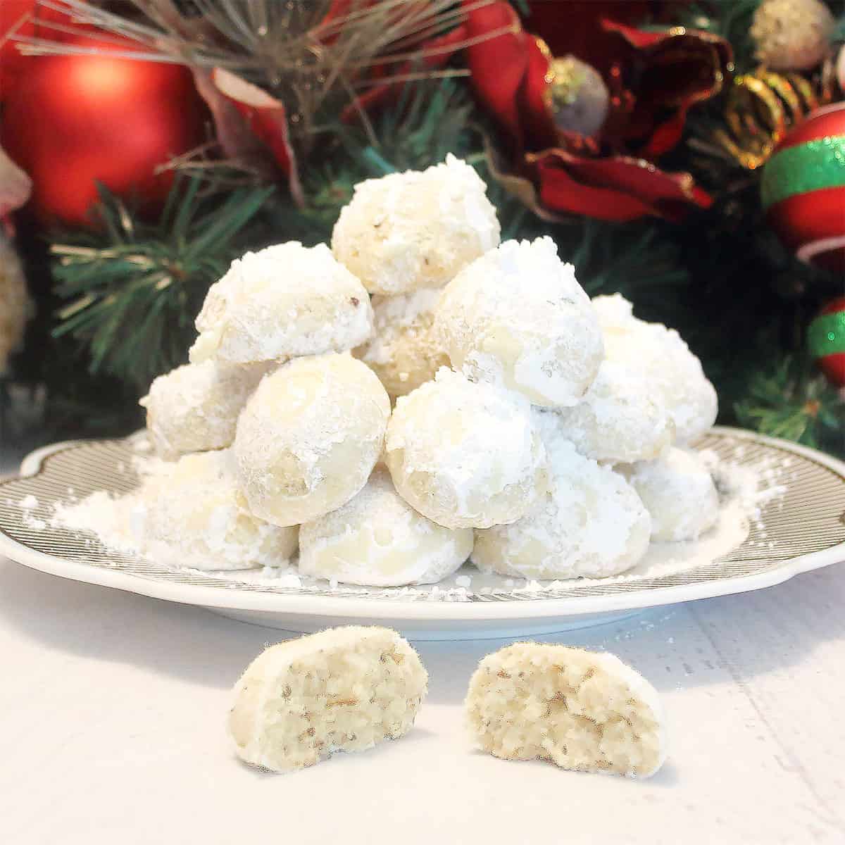Brazil Nut Snowball Cookies on plate with halved one in front.