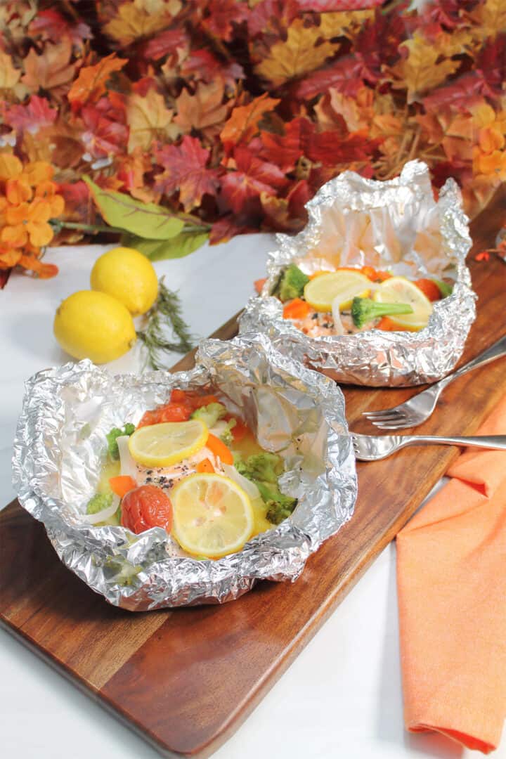 Two foil baked salmon dinners in foil packet.