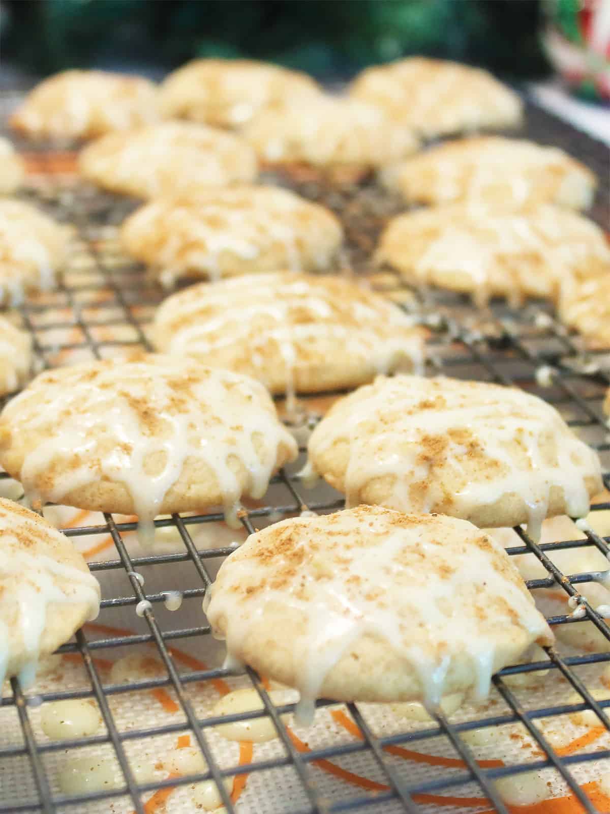 Finished cookies with icing and sprinkle of nutmeg on wire rack.